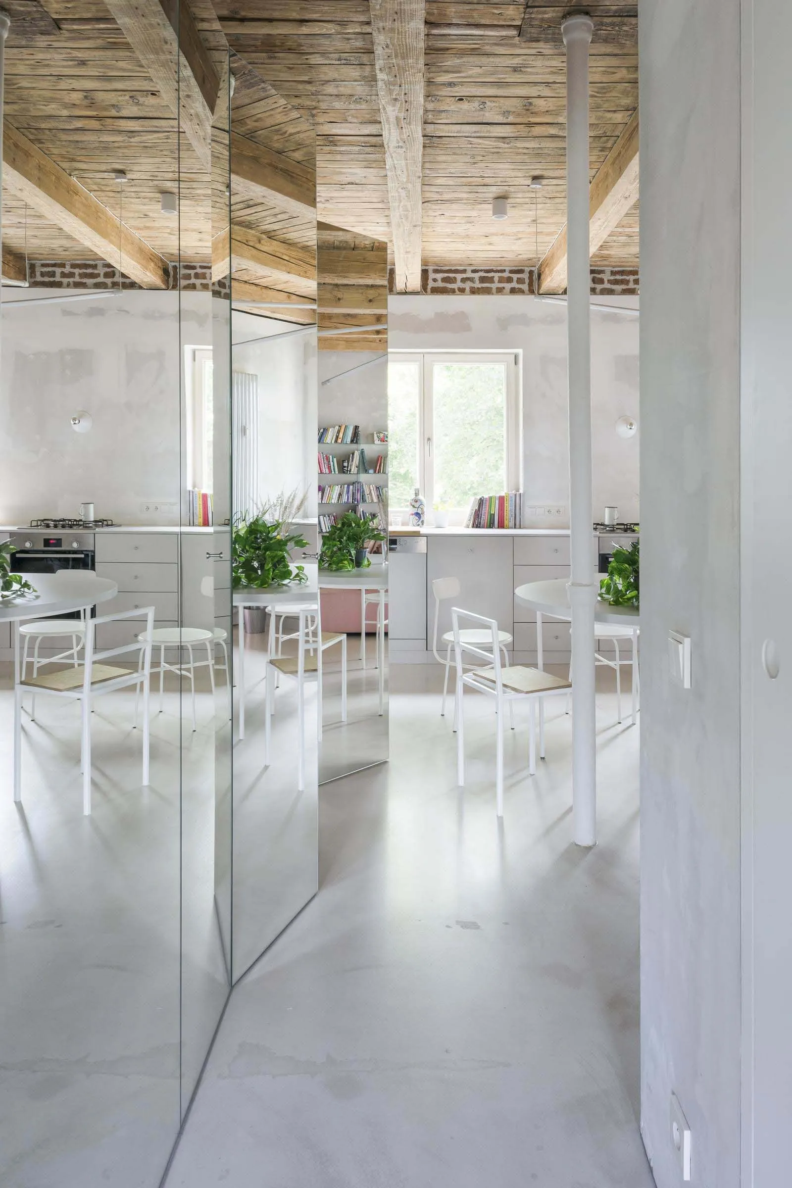 A minimalist industrial kitchen with a white concrete ceiling and modern furniture.