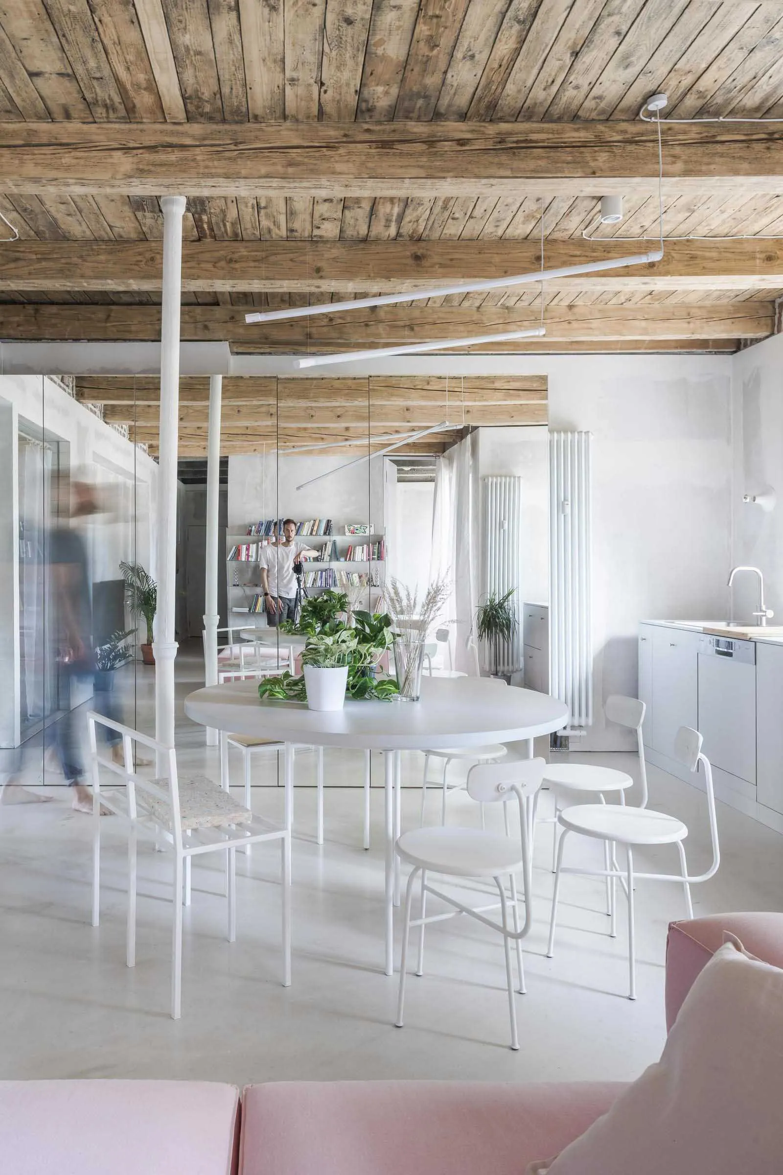 Living room with minimalist style, featuring white steel furniture and concrete floor.