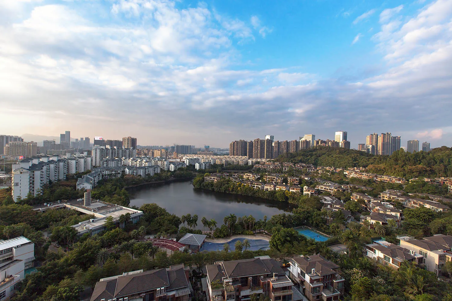 現代混凝土、鋼材與玻璃建築環繞綠意與河流的城市景觀