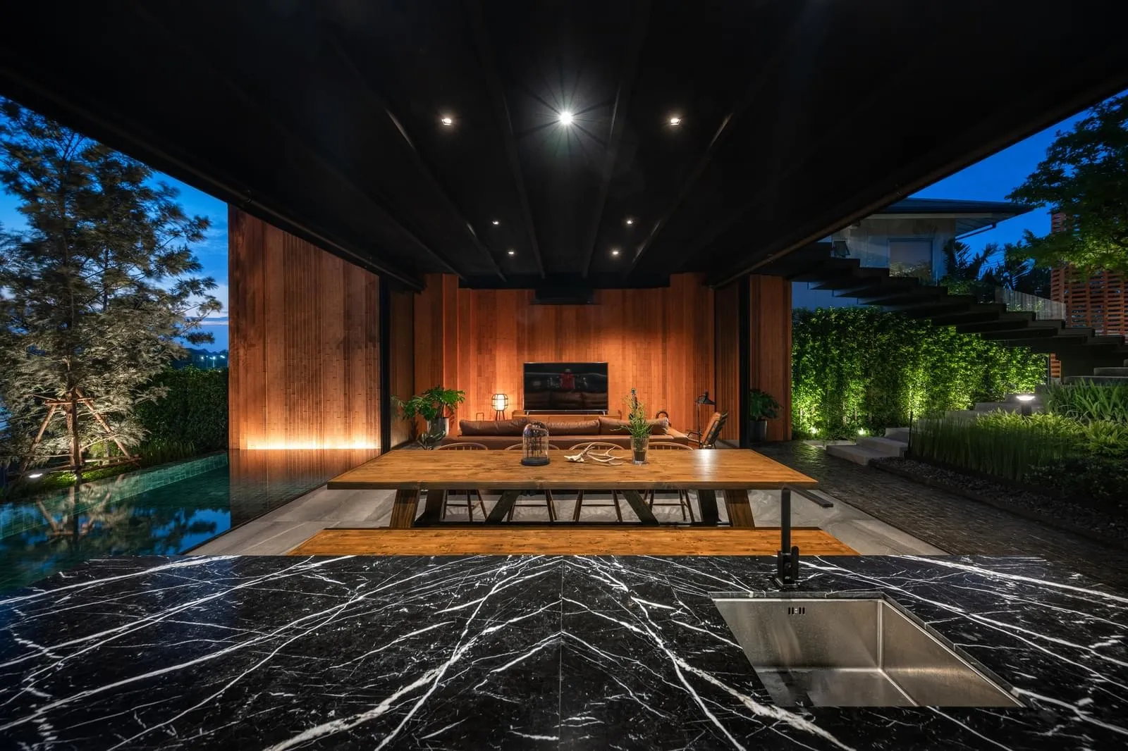 A modern outdoor living space with wooden accents and a large table.