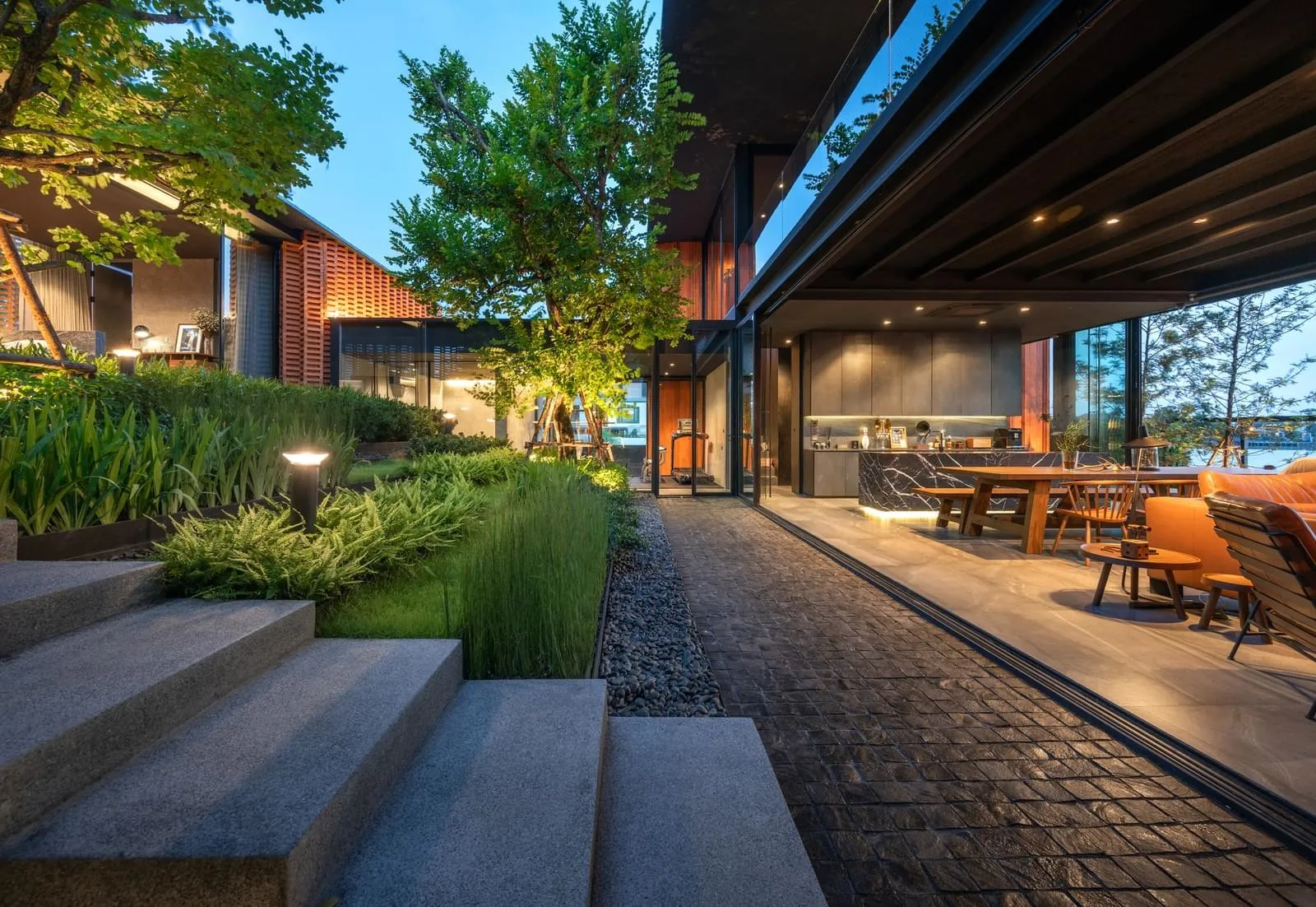 A modern residential exterior with a landscaped garden featuring concrete steps and greenery.
