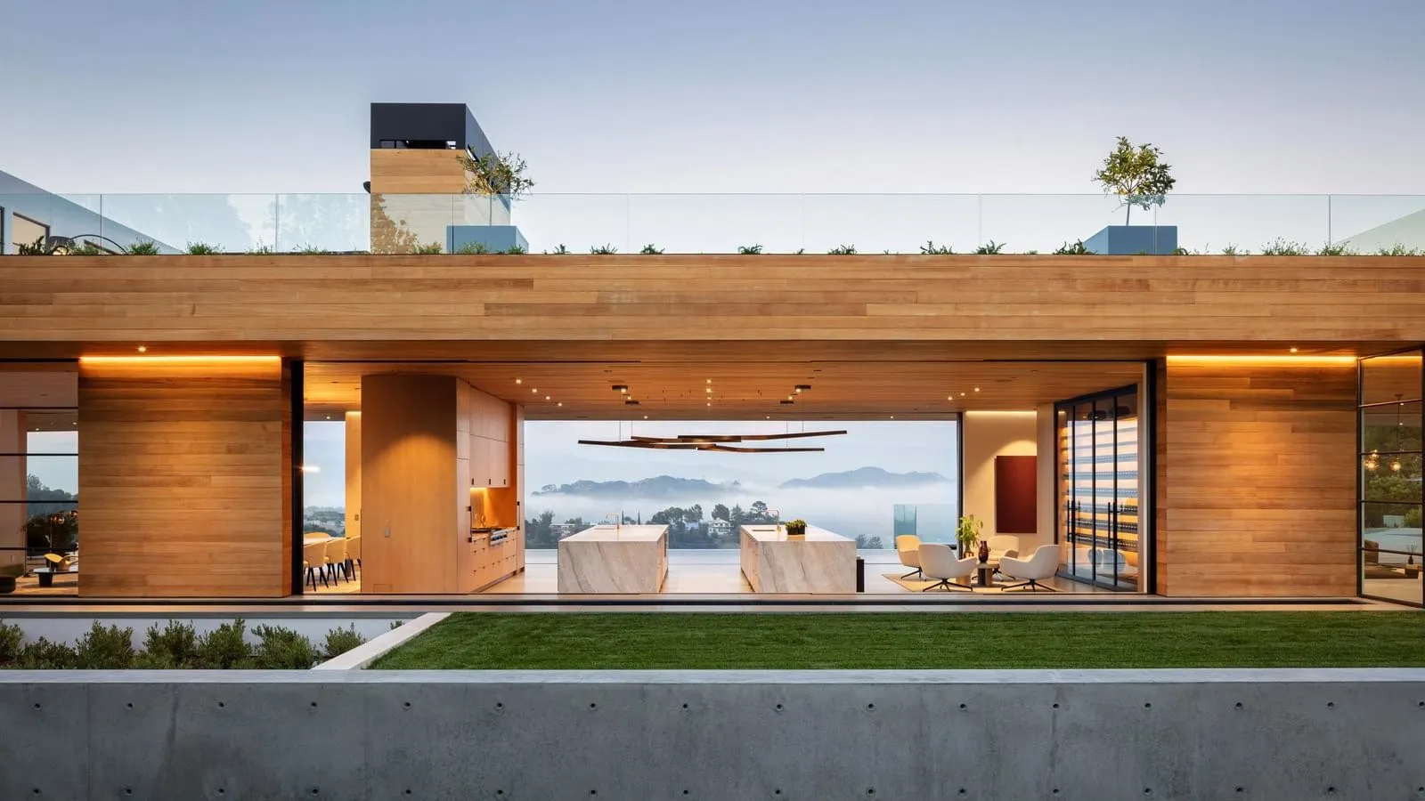 A modern residential interior featuring wooden walls and large windows with a view of a foggy landscape.