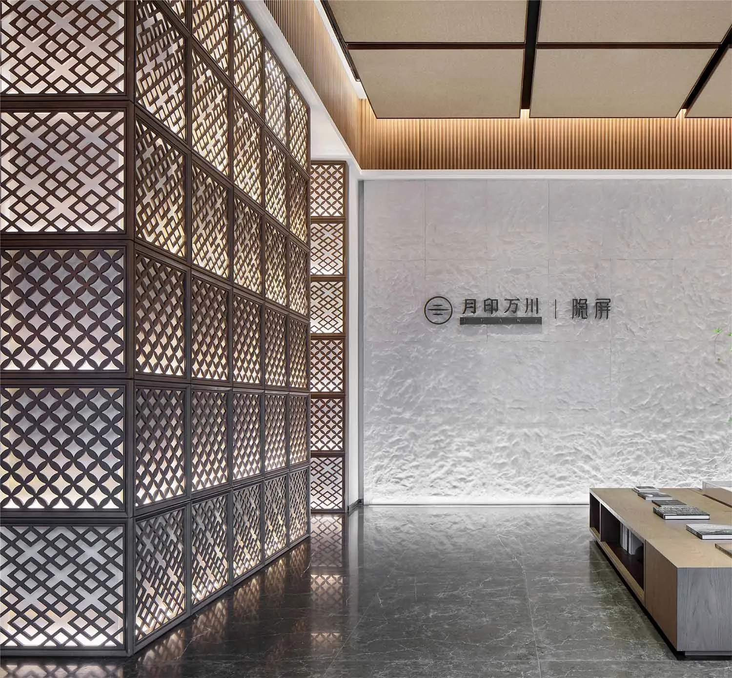 Modern office entryway with a middle gray matte black floor and a lattice wall with a light fixture.