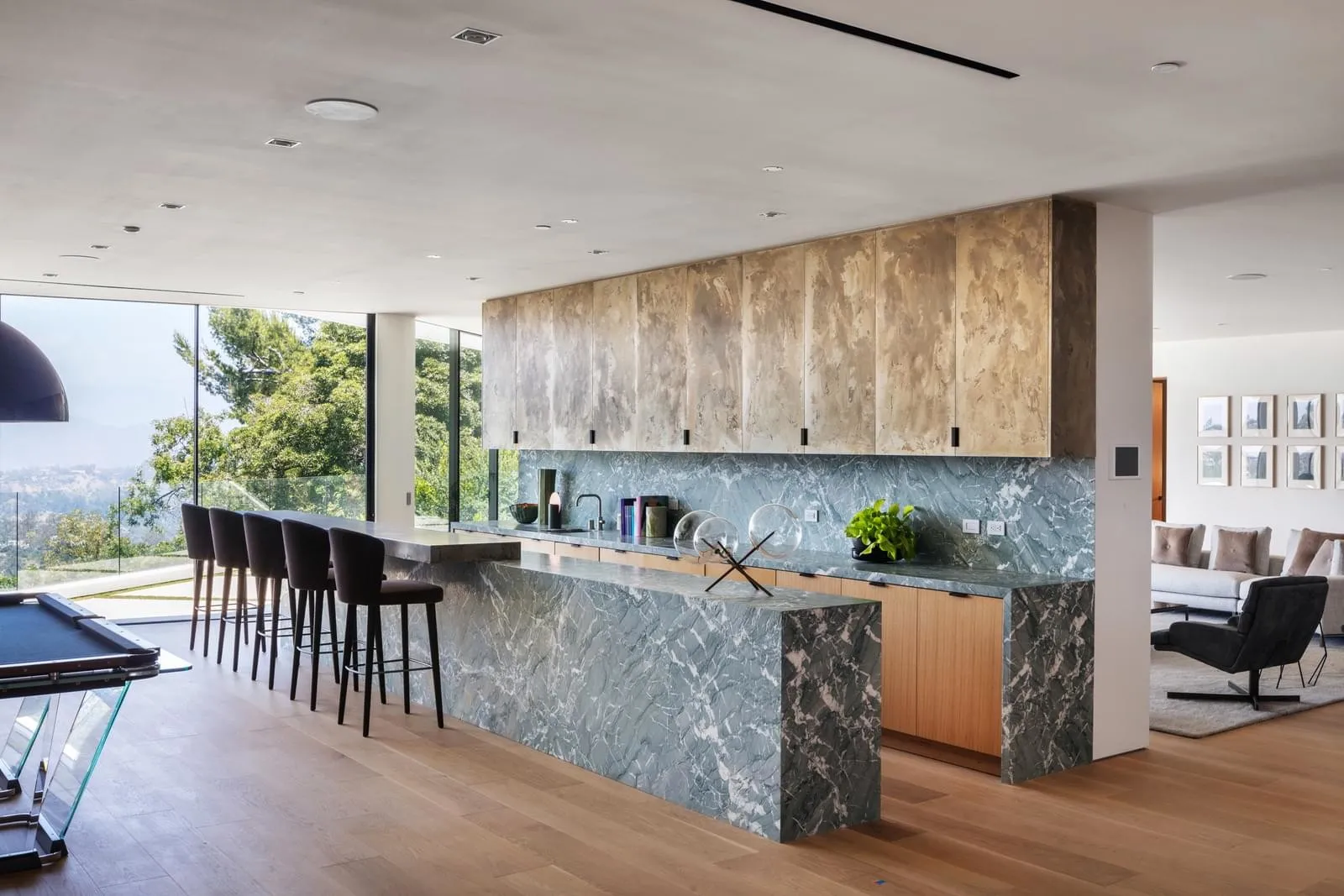 A modern kitchen with a marble island and ample seating.