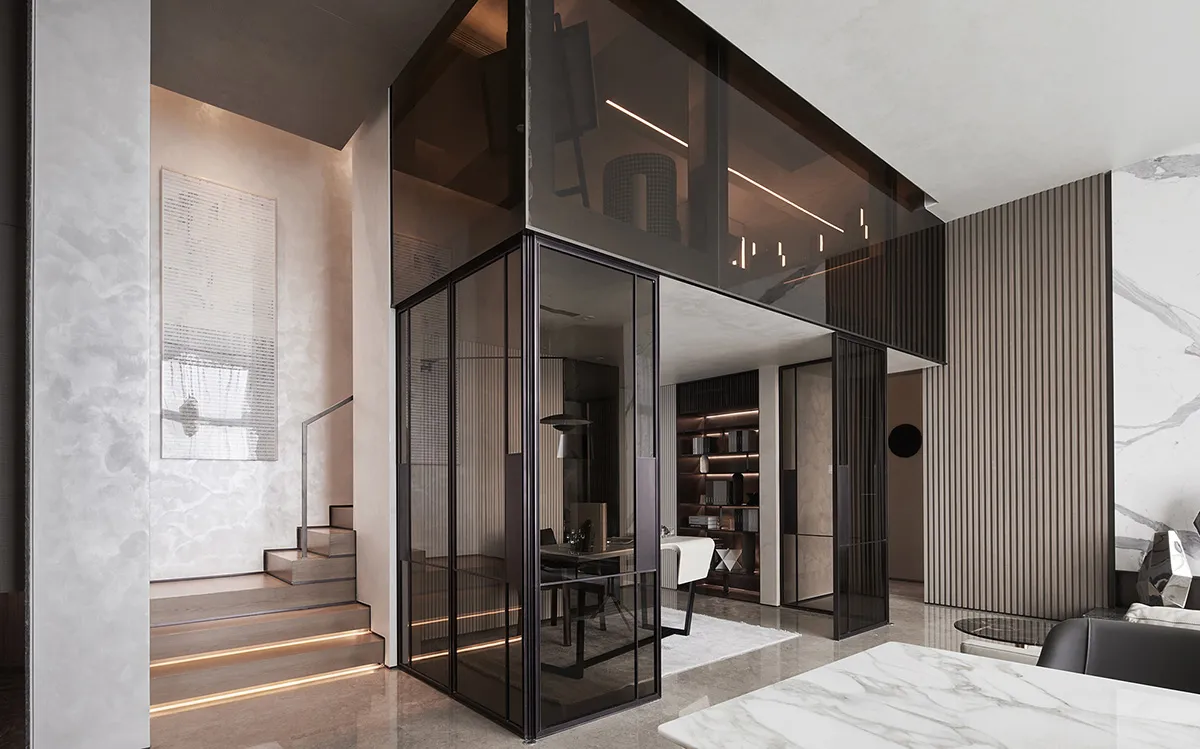 A modern home office featuring glass walls, marble finishes, and a staircase.