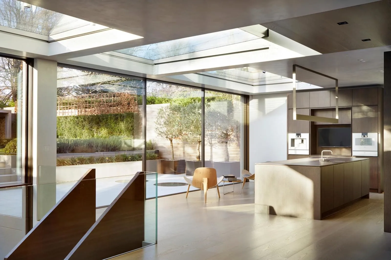 Modern minimalist kitchen featuring wood, glass, and metal elements.