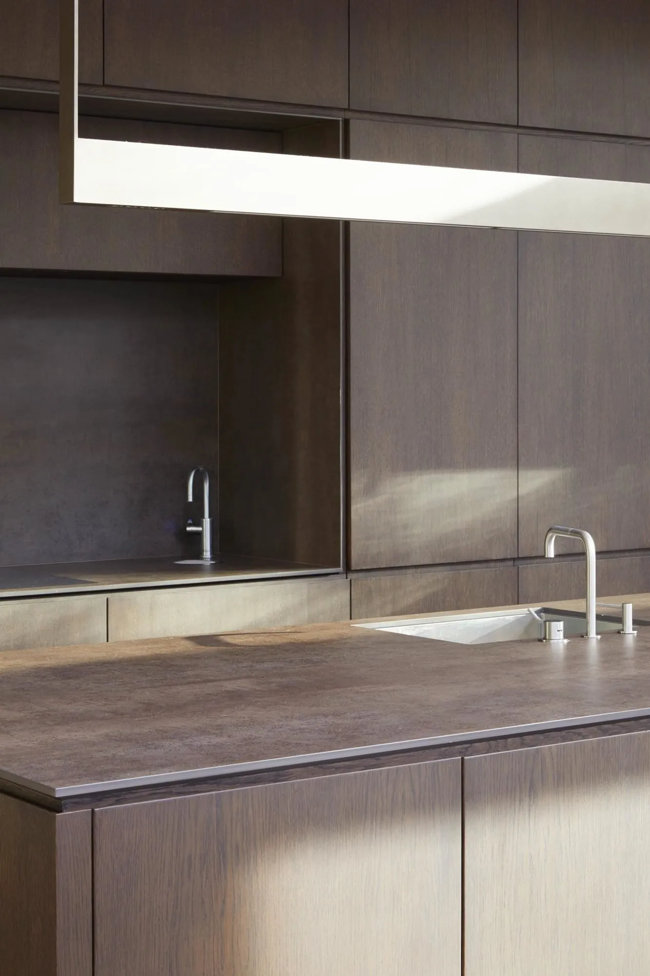 Modern minimalist kitchen with wooden cabinets and sleek design.