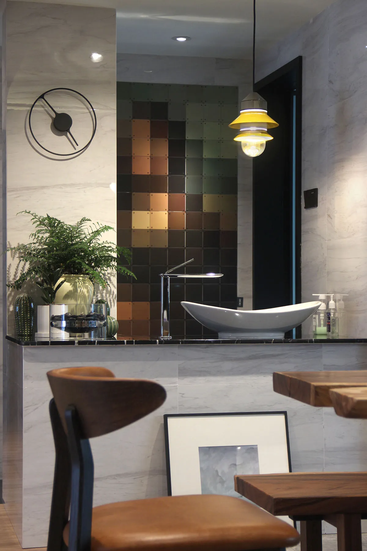 Modern minimalist bathroom featuring marble tiles, a sleek sink, and contemporary lighting.