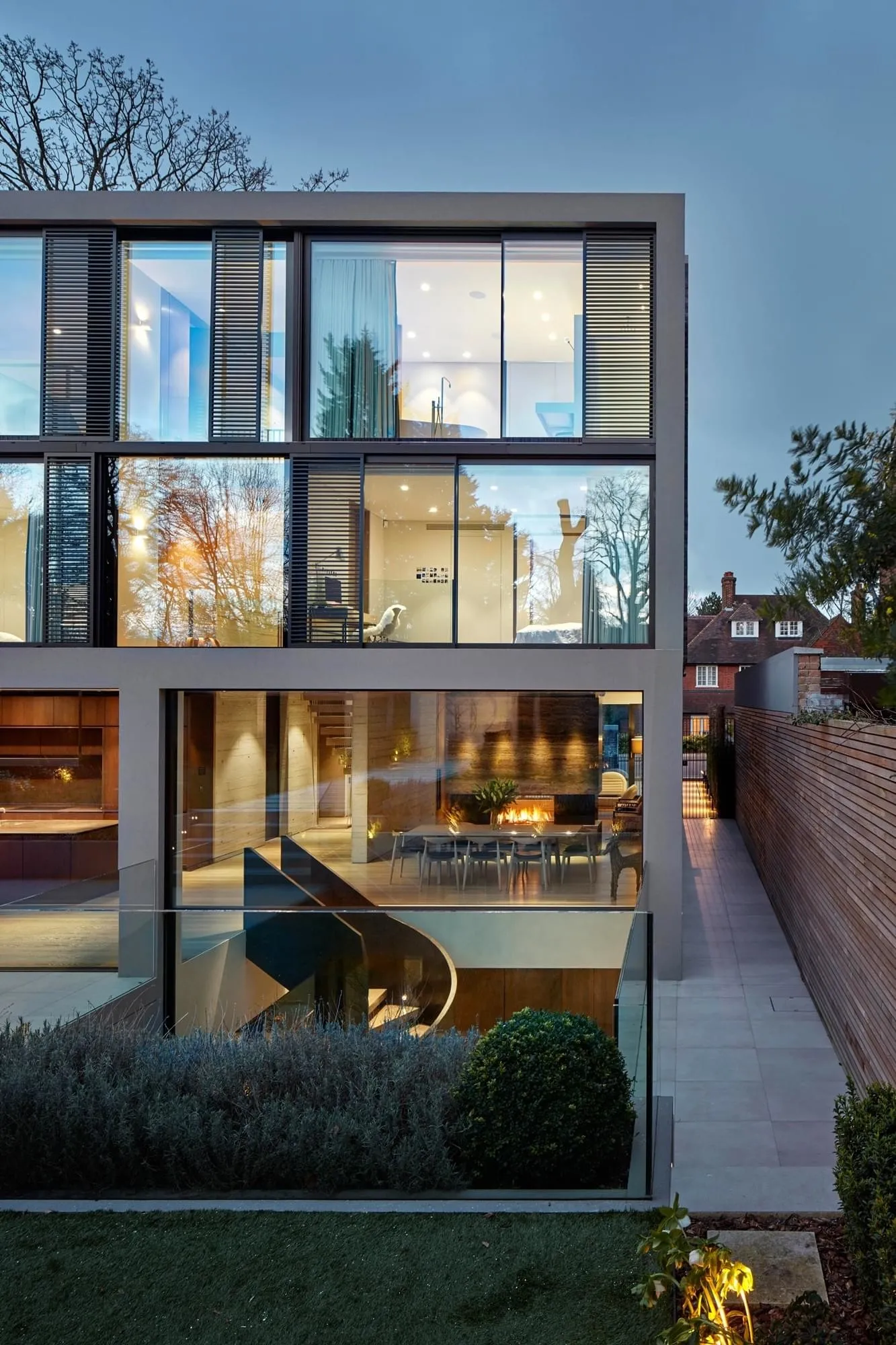 A modern interior with large glass walls, interior lighting, and a spacious layout.