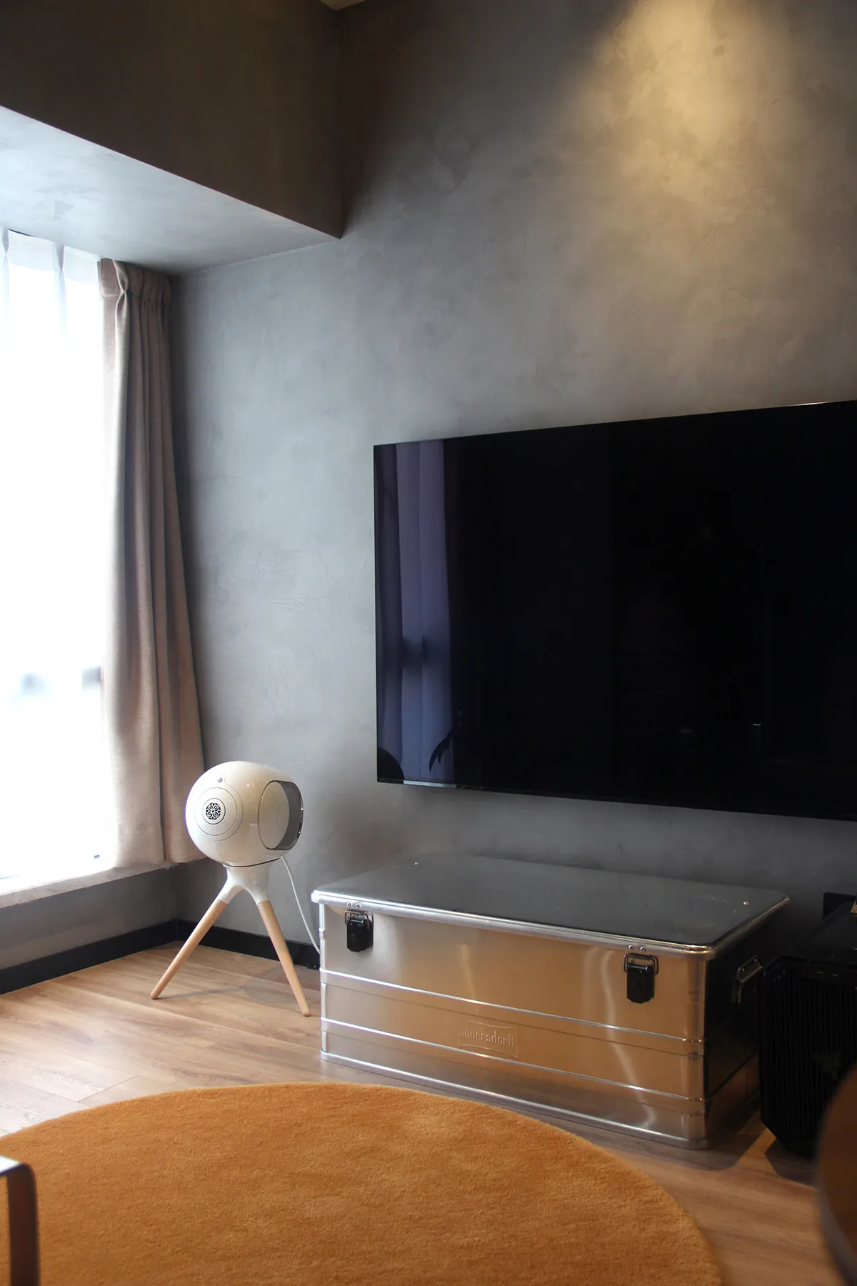 A modern living room featuring a metallic box and a large screen television.