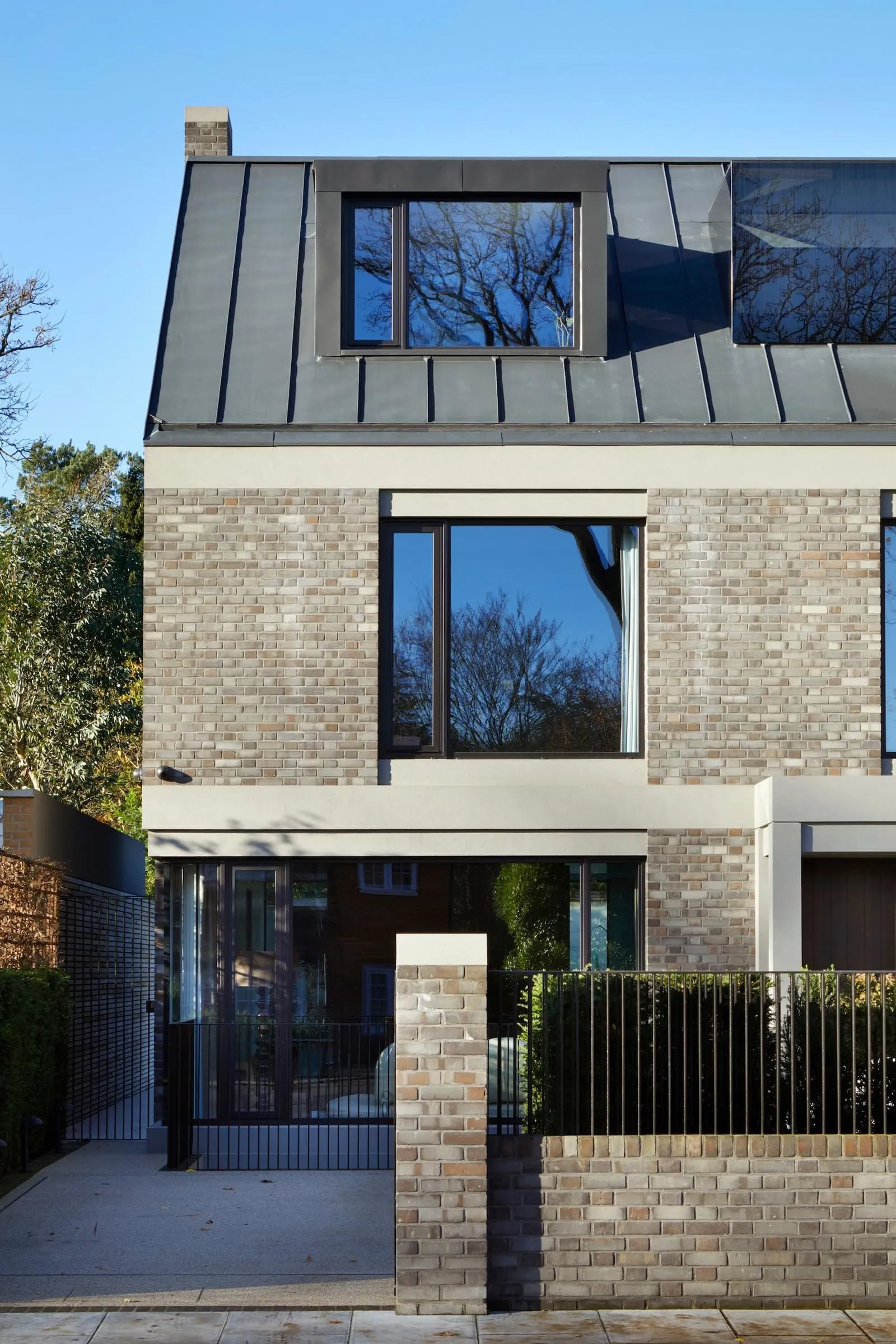 Modern residential exterior with brick facade and large windows.