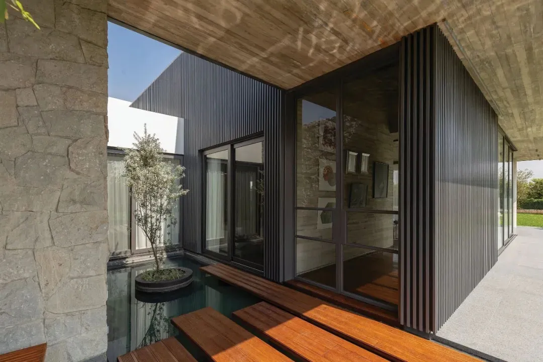 A minimalist architectural exterior featuring concrete and glass materials.