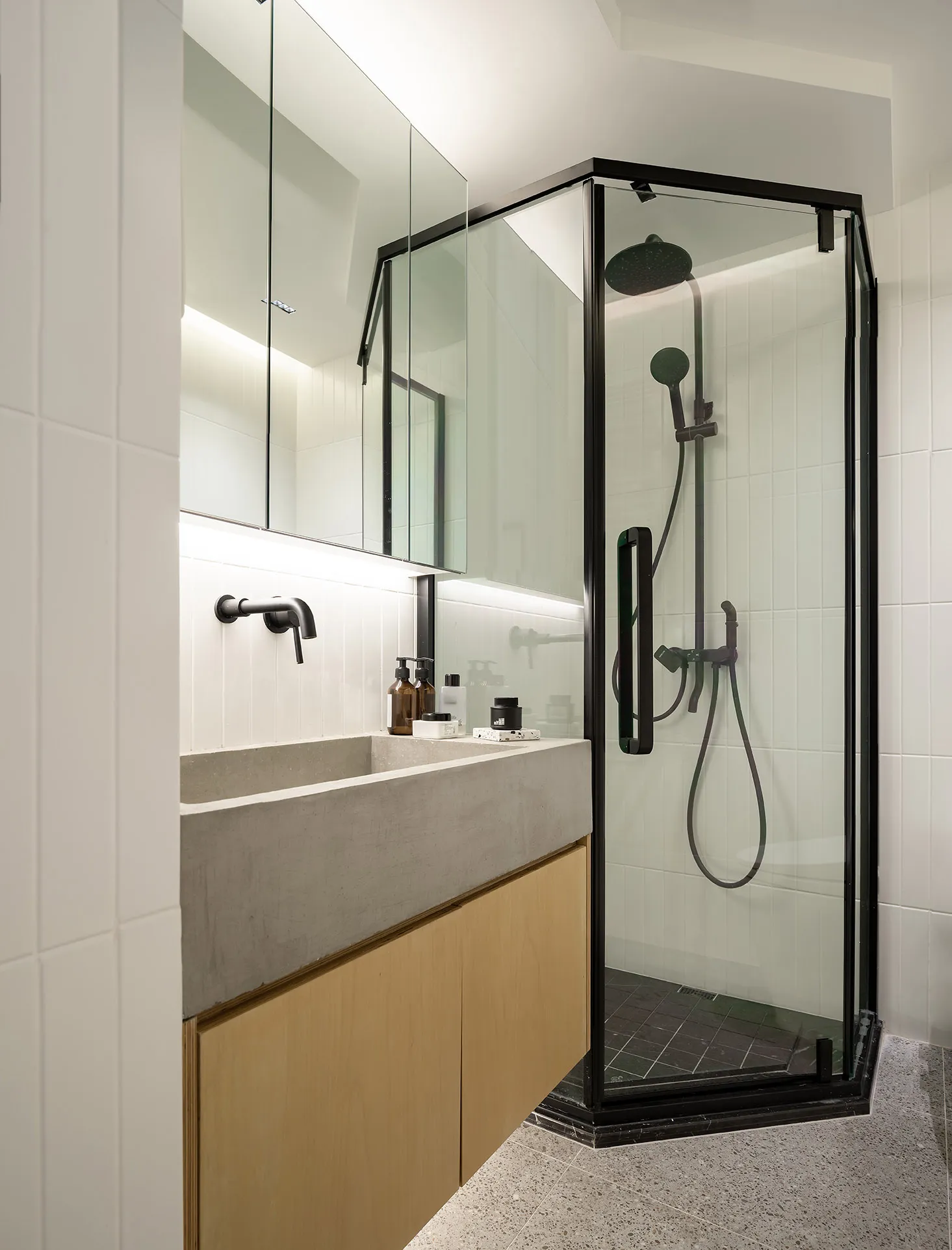 Modern minimalist bathroom featuring a concrete sink and glass shower enclosure.
