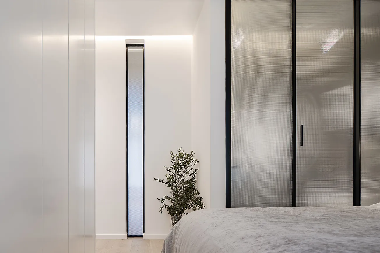 Modern minimalist bedroom featuring glass and metal elements.