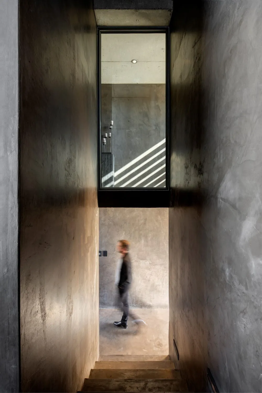 A minimalist, modern staircase with concrete walls.