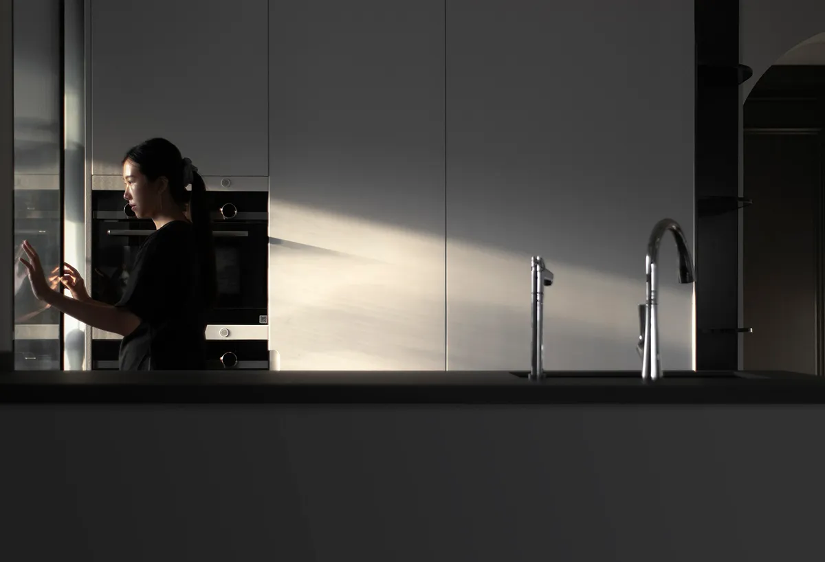 A minimalist kitchen with modern design elements such as glass and stainless steel