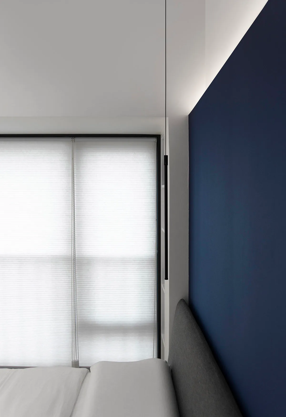 Modern minimalist bedroom featuring window blinds.
