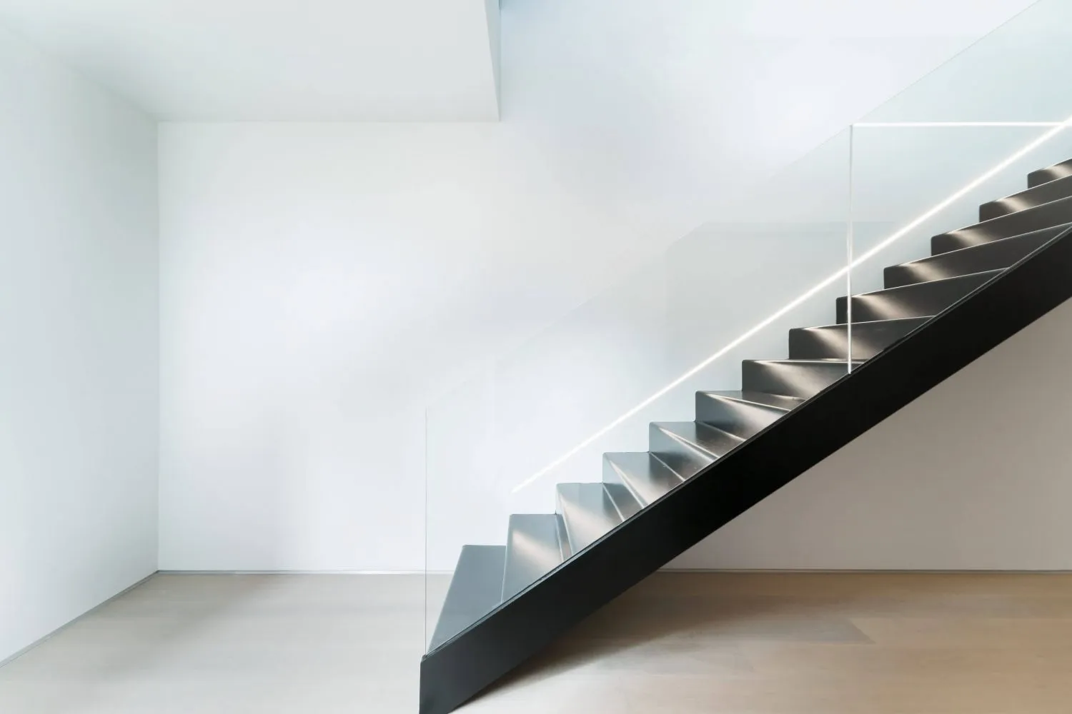 Metal stairs with glass railing in a minimalist interior space