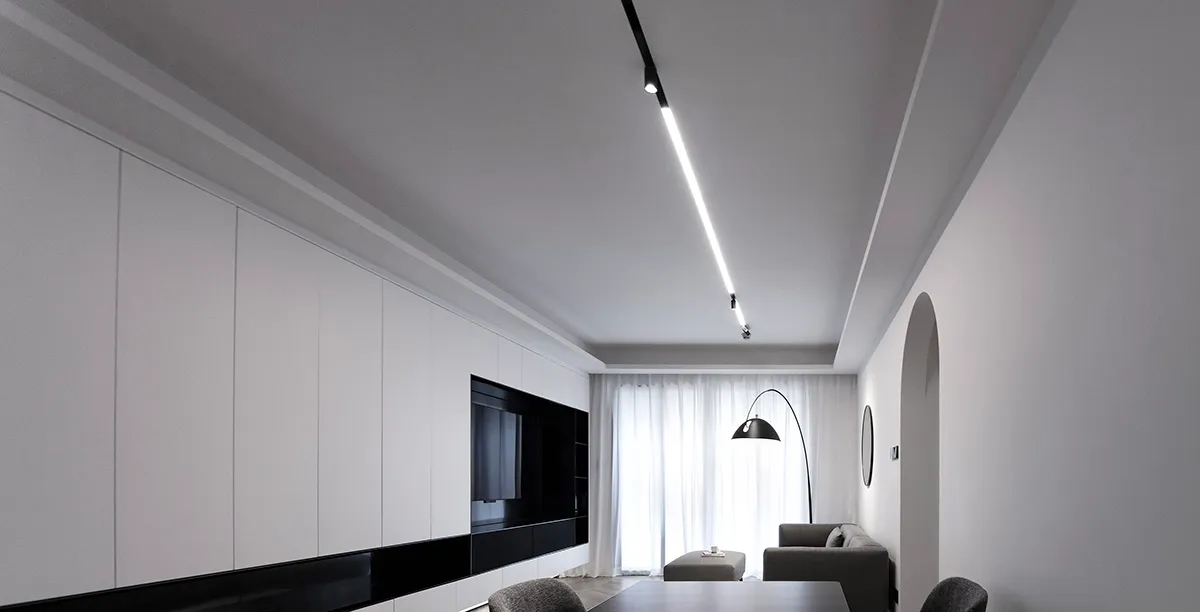 Modern minimalist living room with white walls and black accents.