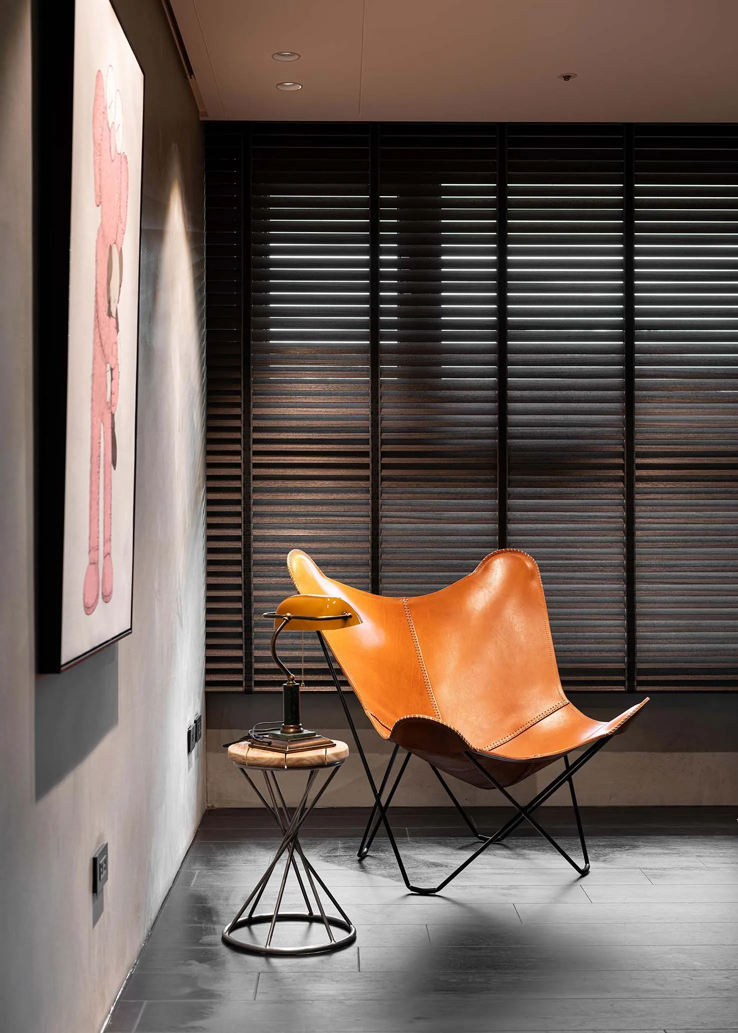 A minimalist living room featuring a modern leather butterfly chair with metal legs.