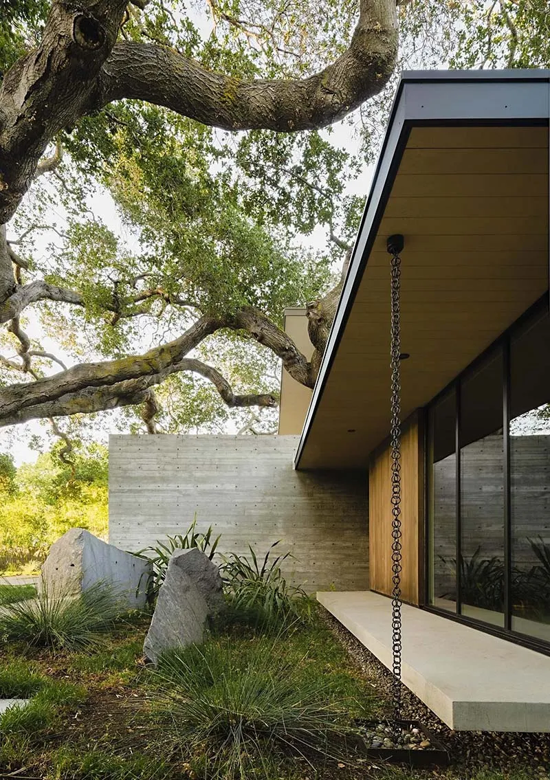 Modern residential exterior featuring concrete, wood, and glass materials