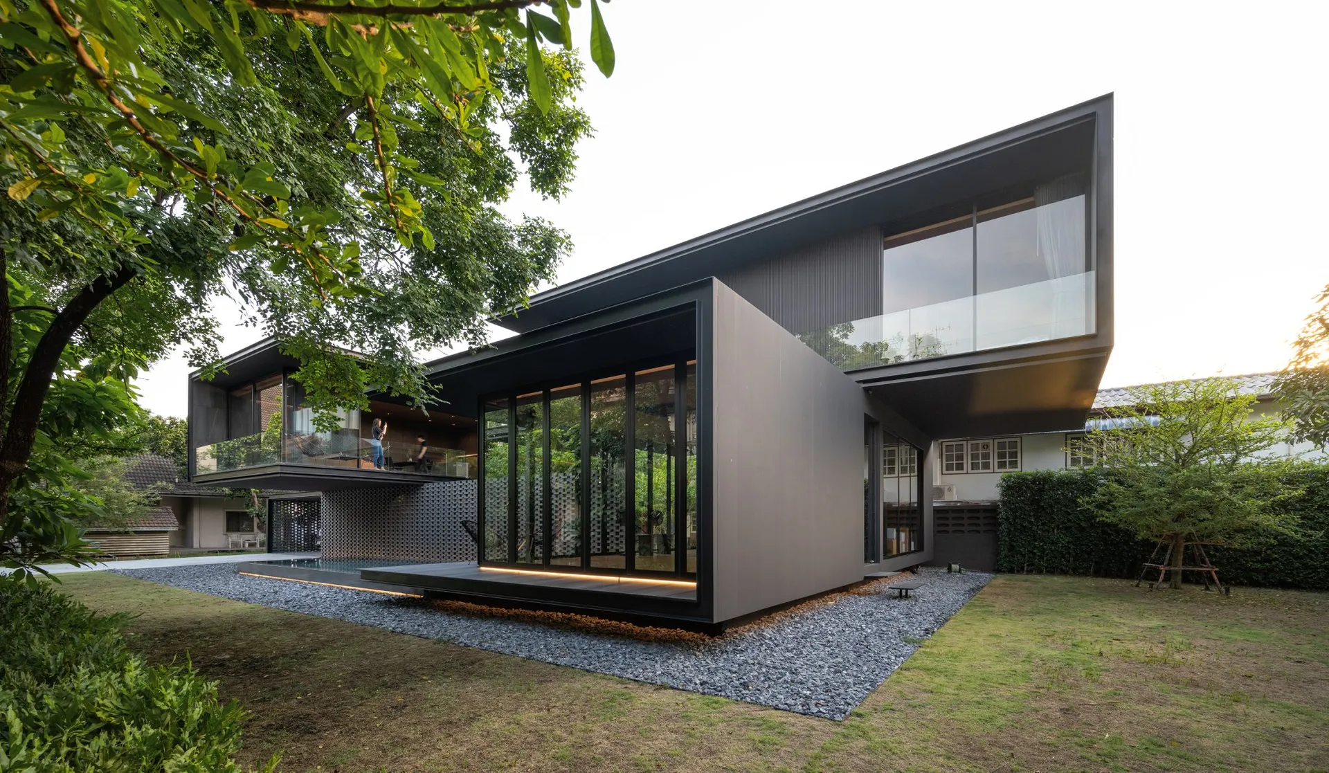 Modern minimalist house exterior with metal cladding and large glass windows.