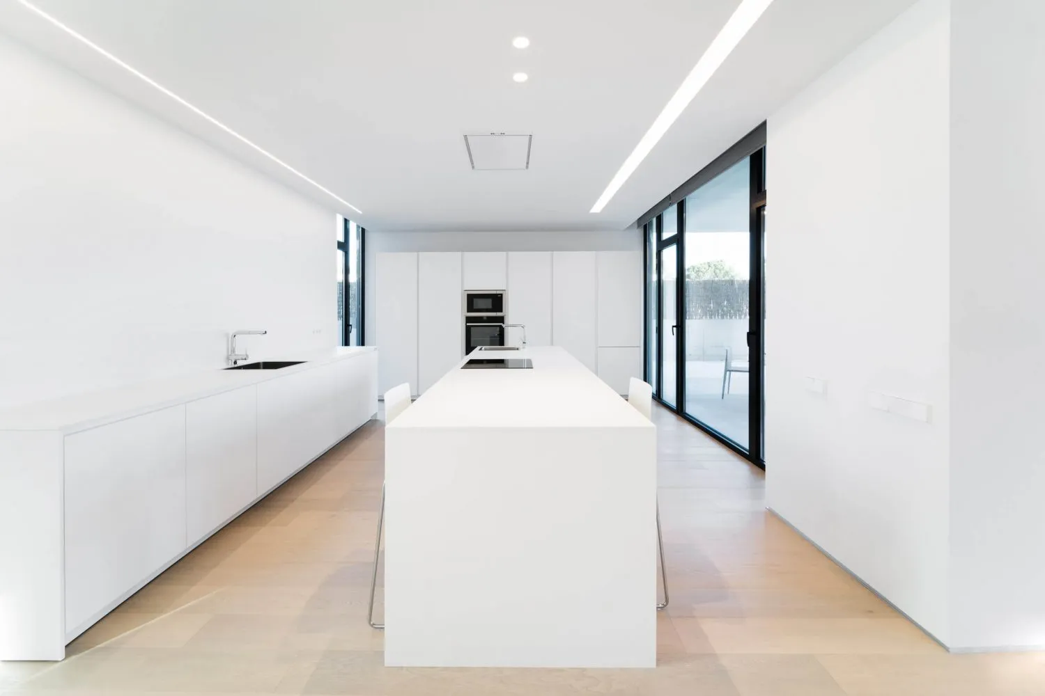 Modern, white kitchen with sleek, minimalist design.