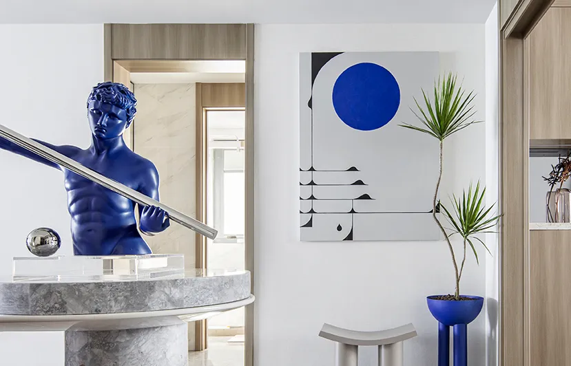 A contemporary entryway with polished concrete floors, a blue marble sculpture, and a blue and white geometric painting.