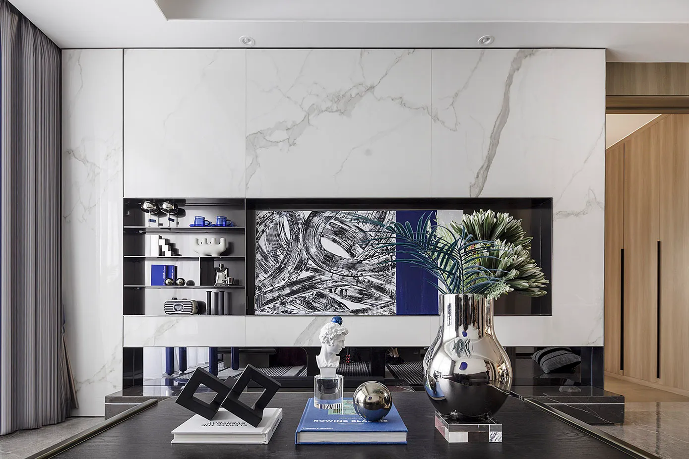 Modern interior design featuring a living room with marble finishes and contemporary decor elements.