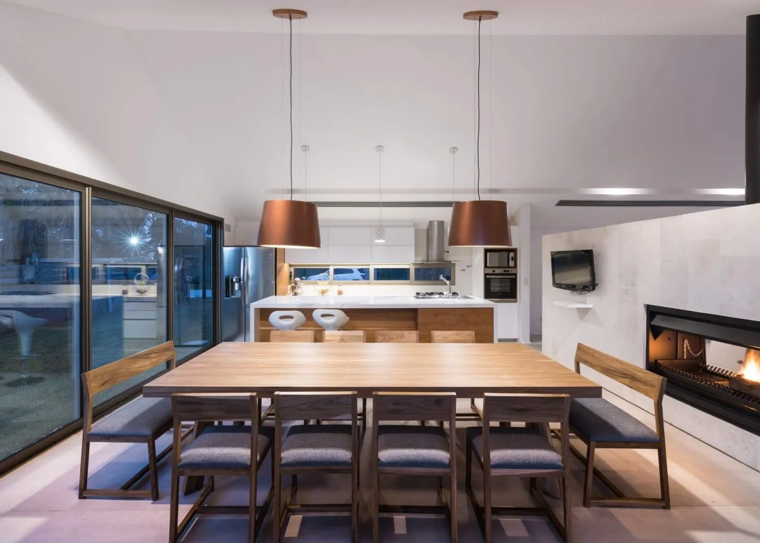 Modern residential interior with a wooden dining table and kitchen island