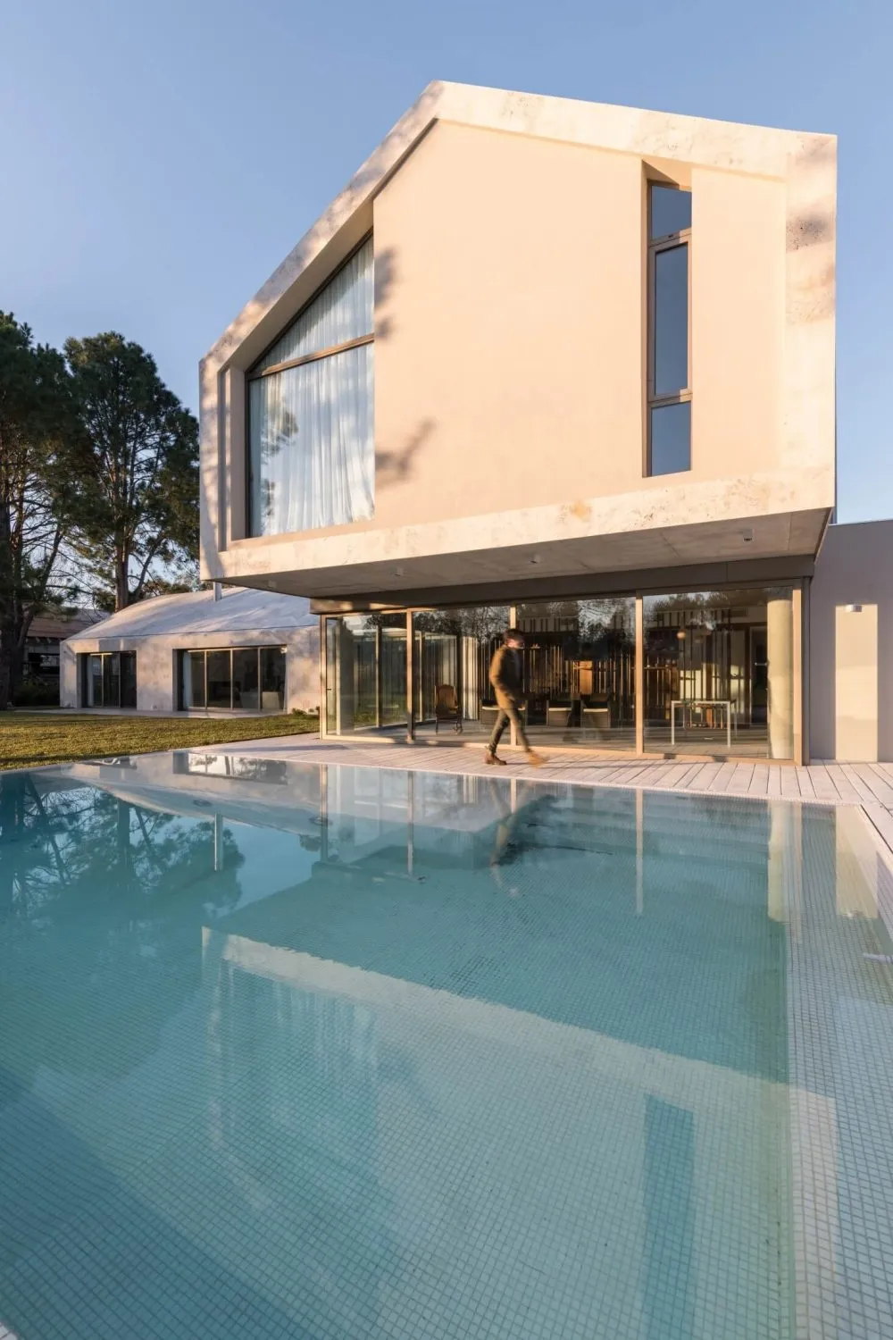 A modern residential building with a concrete exterior and large glass windows.