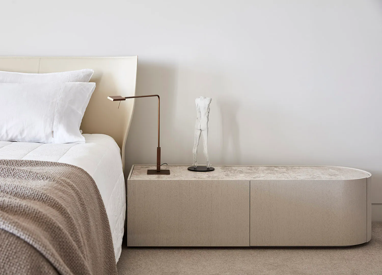 A minimalist bedroom featuring modern materials and sleek, streamlined furniture.