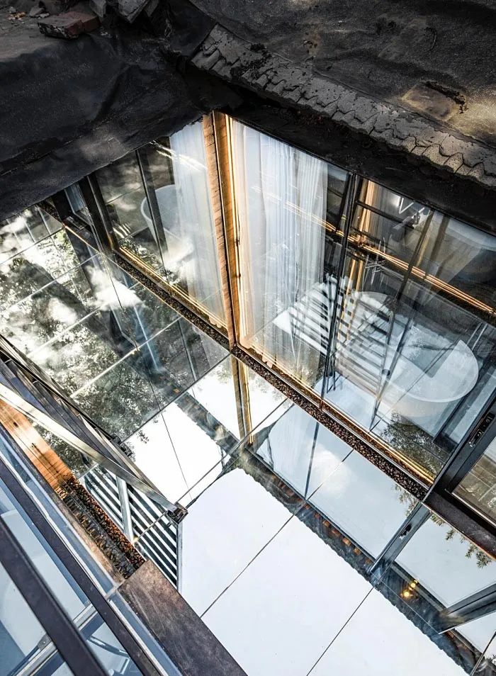 A minimalist interior design with large glass windows and panels.