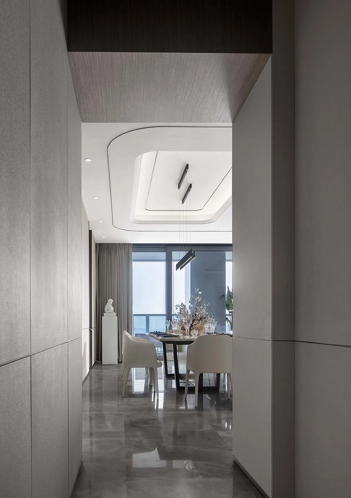 Modern dining room featuring a sleek tile wall and contemporary light fixtures.