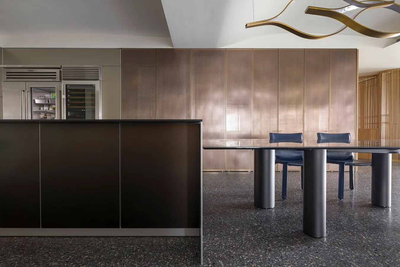Modern industrial kitchen with metal panels and dark countertops.