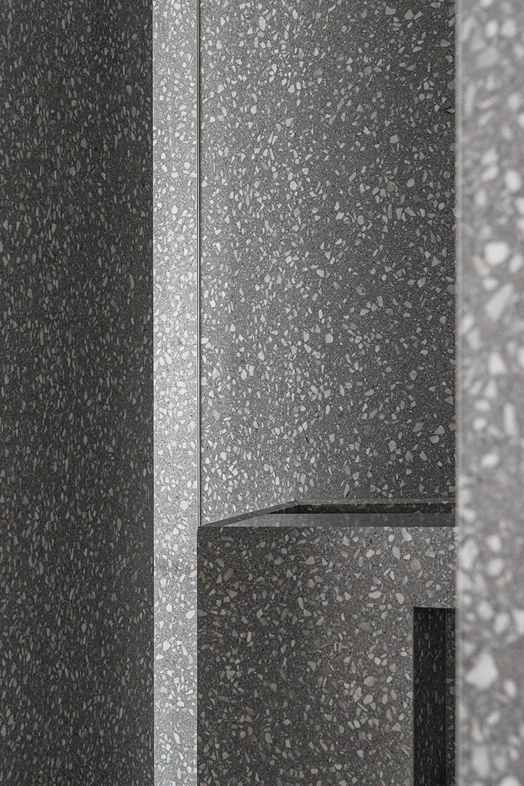 Modern interior design featuring concrete terrazzo flooring and walls.