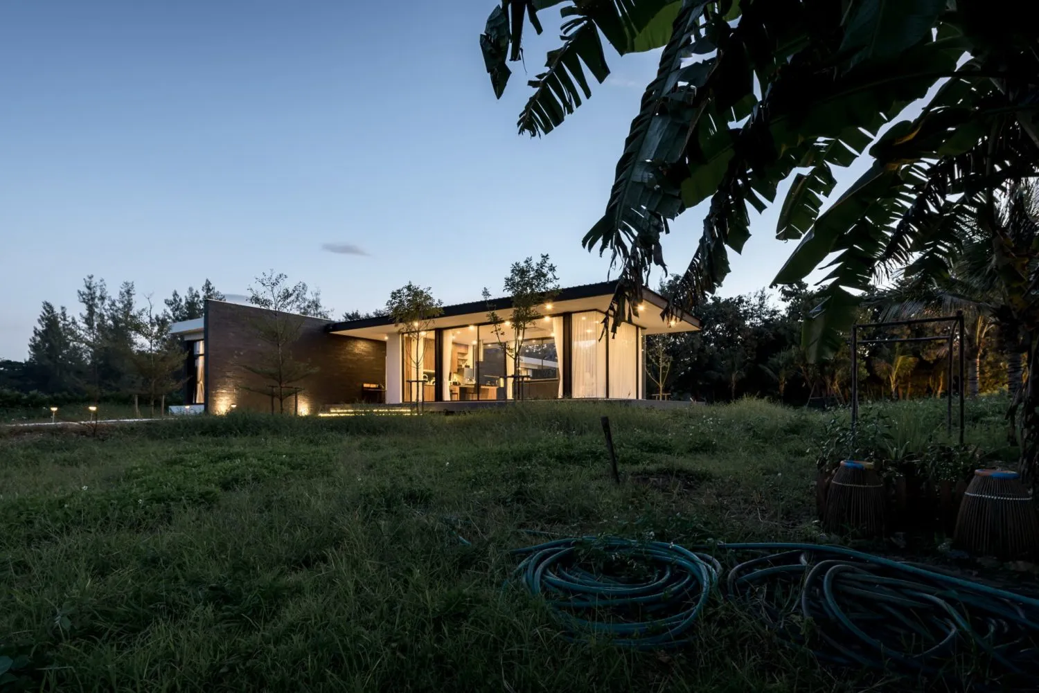 A modern residential interior featuring glass elements against a night sky background.