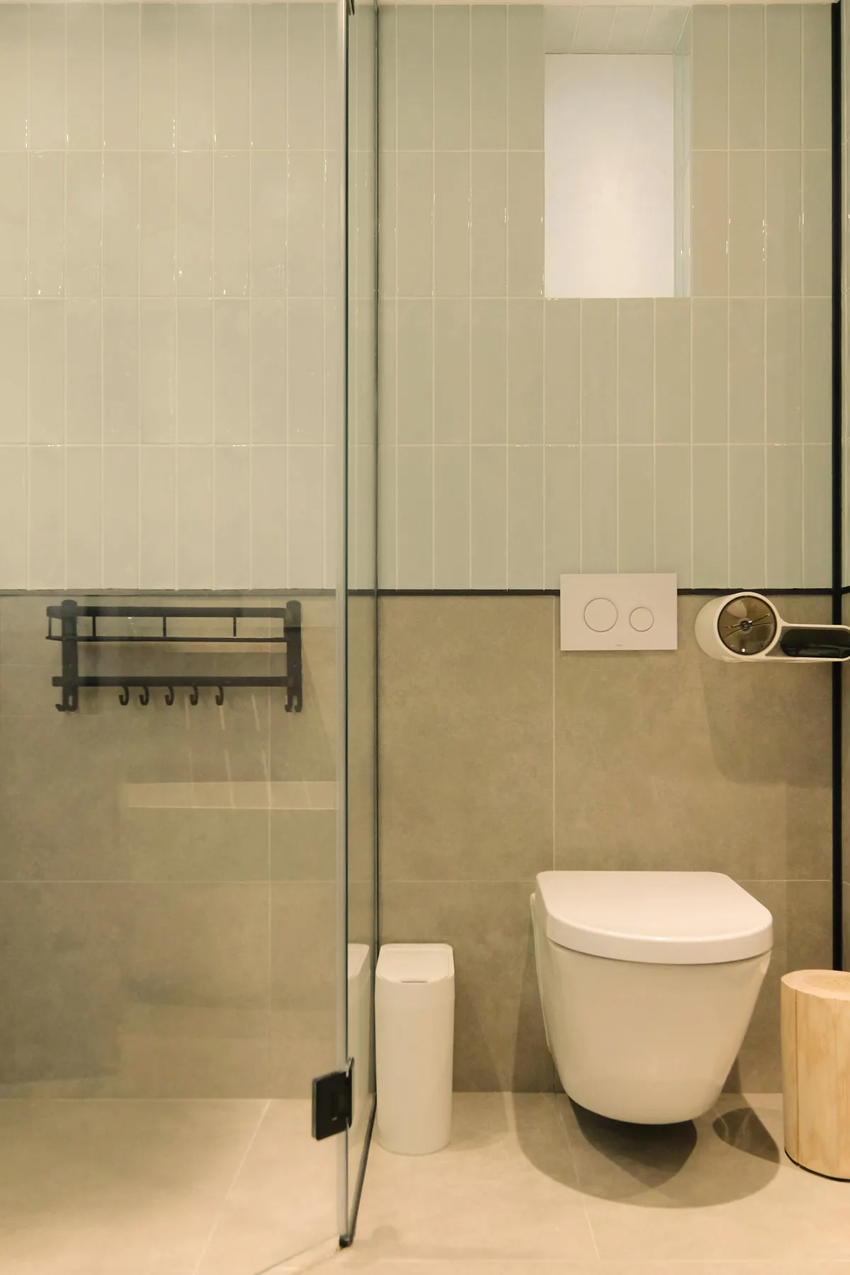 A modern minimalist bathroom with white tiles and a white toilet.