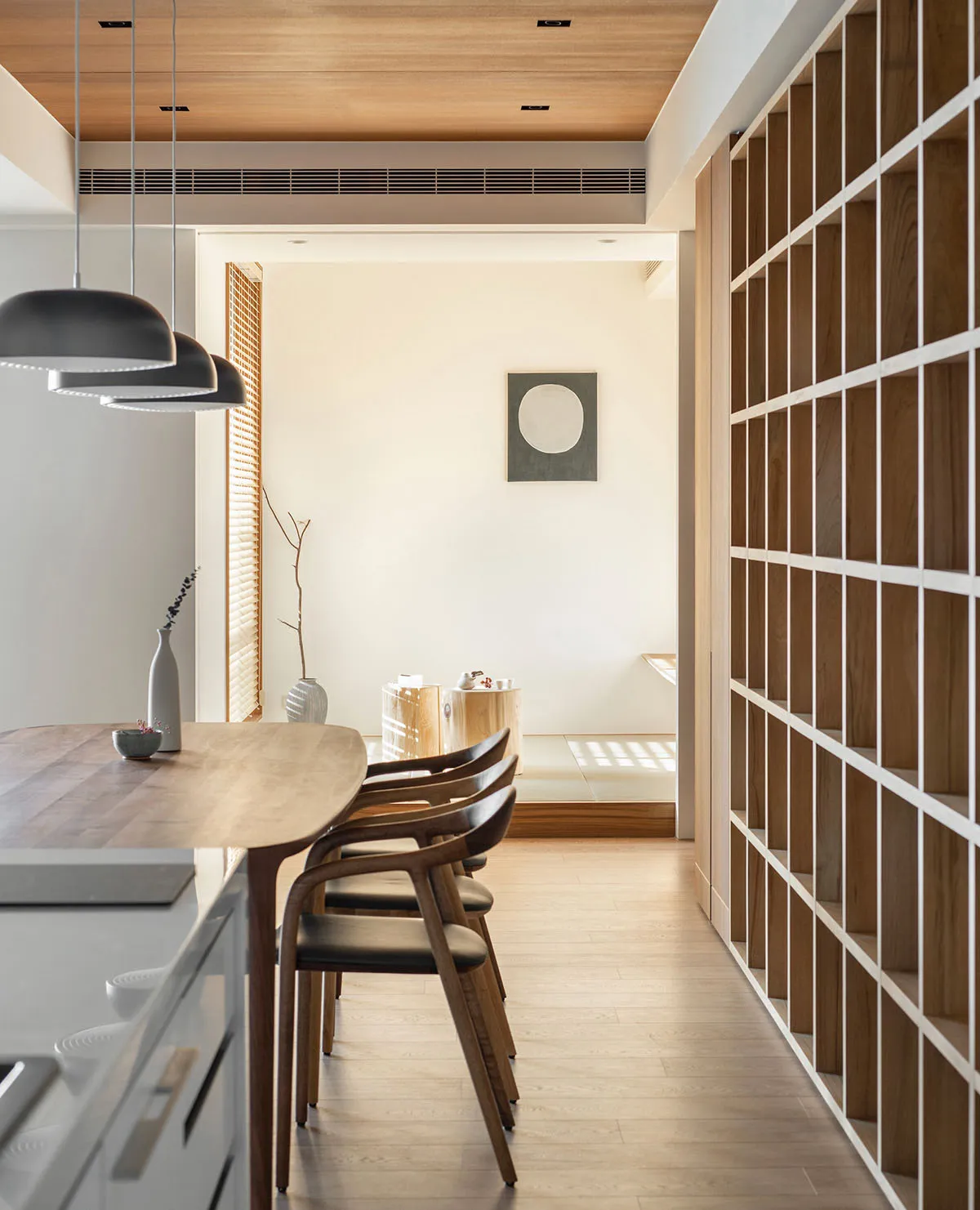 Modern dining room featuring natural wood elements, including chairs and table.
