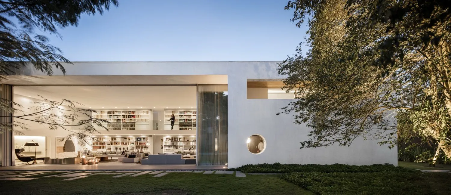 A modern minimalist house with concrete walls and a large open living area.