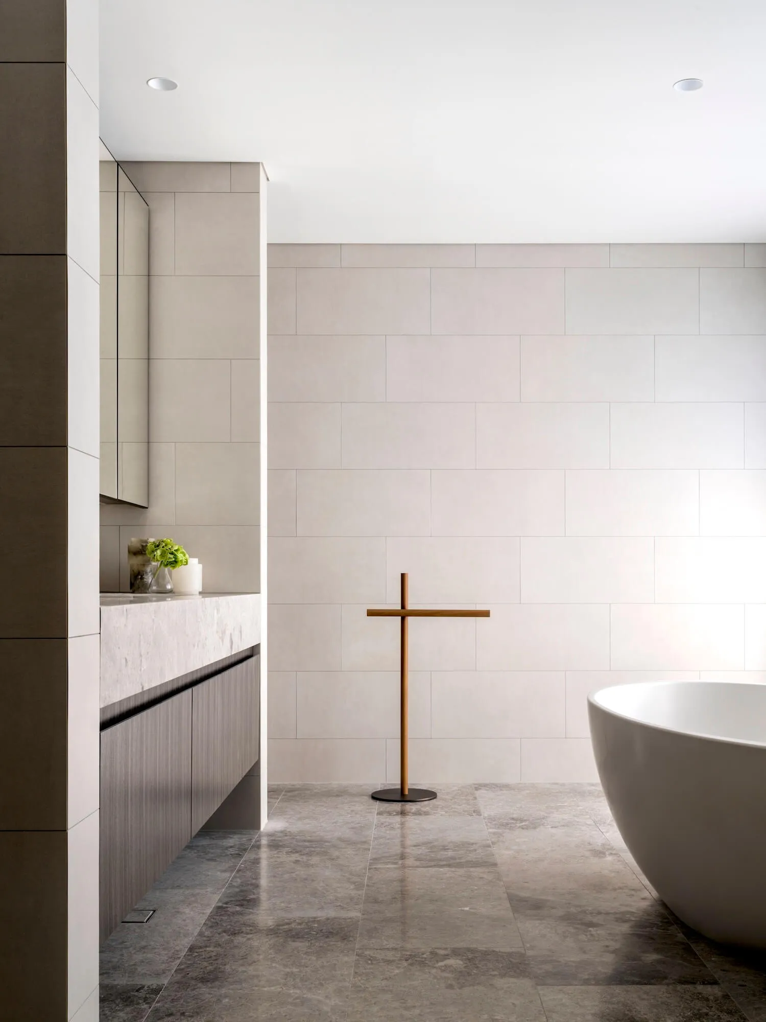 Modern minimalist bathroom with concrete tiles, a sleek freestanding tub, and minimalist decor.
