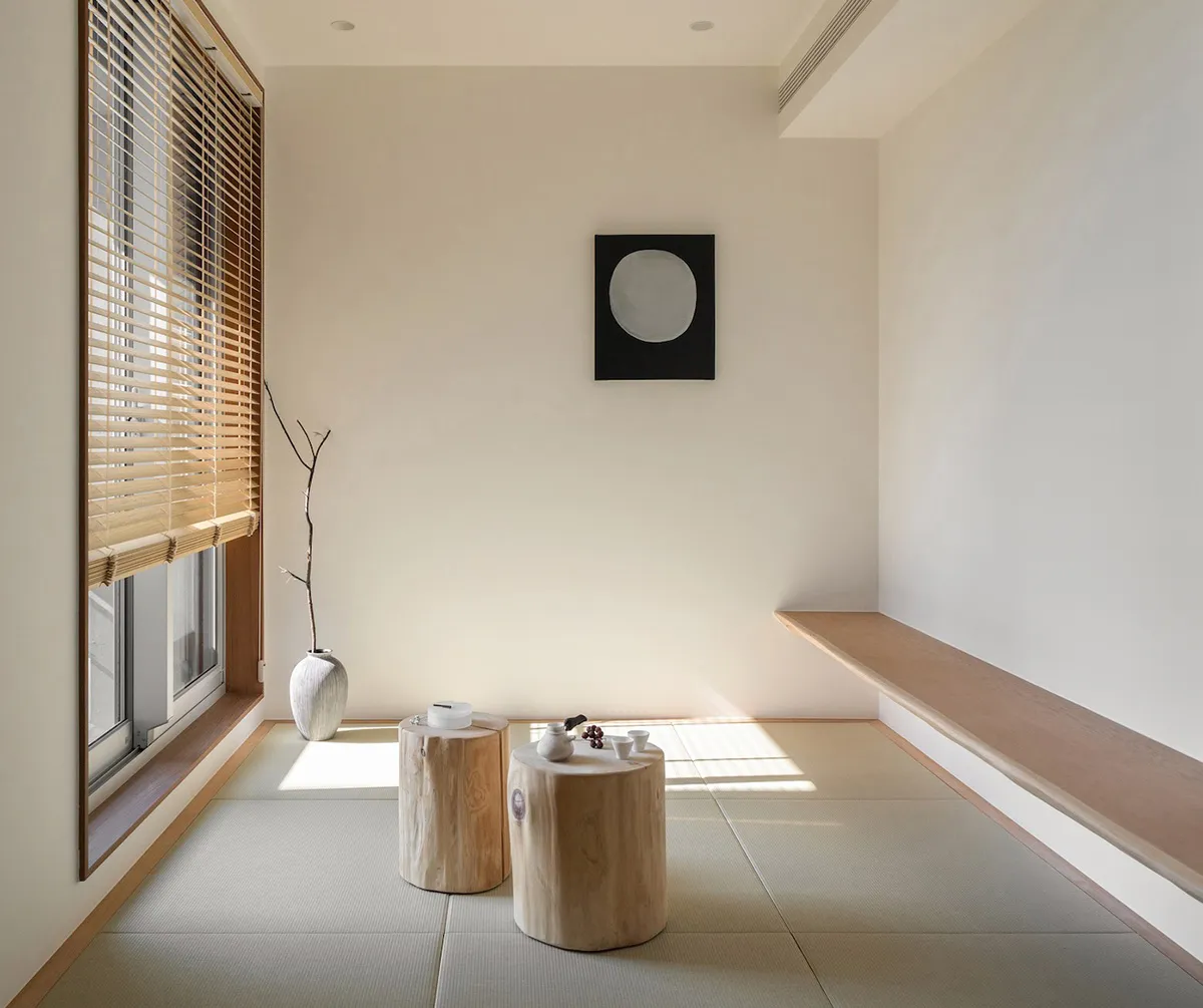 A minimalist living room featuring paper and wooden furniture on a tatami mat floor.