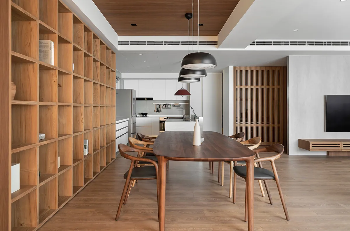 Modern kitchen and dining room with wooden furniture and open shelving.