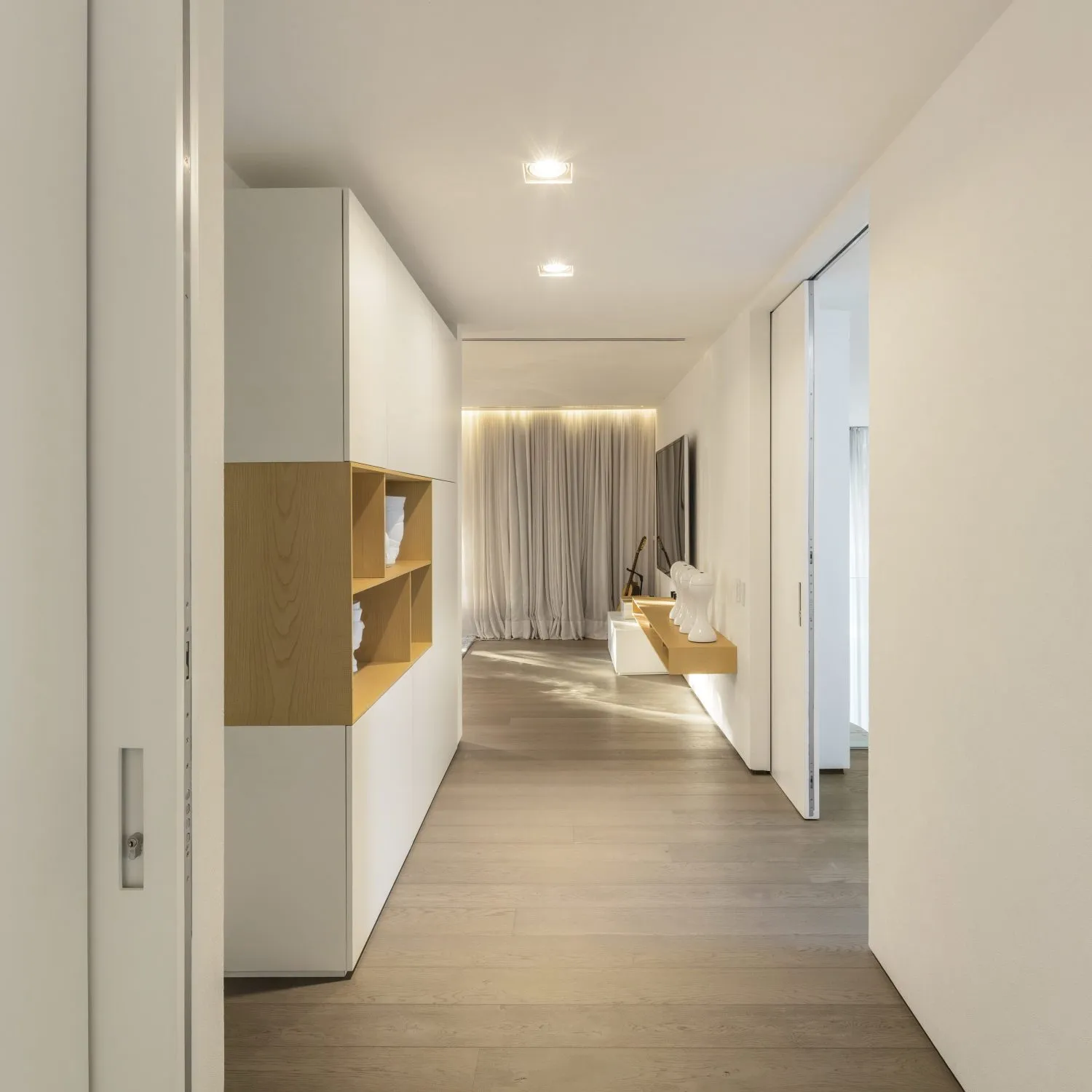 Modern minimalist interior design with light wood flooring and white walls.