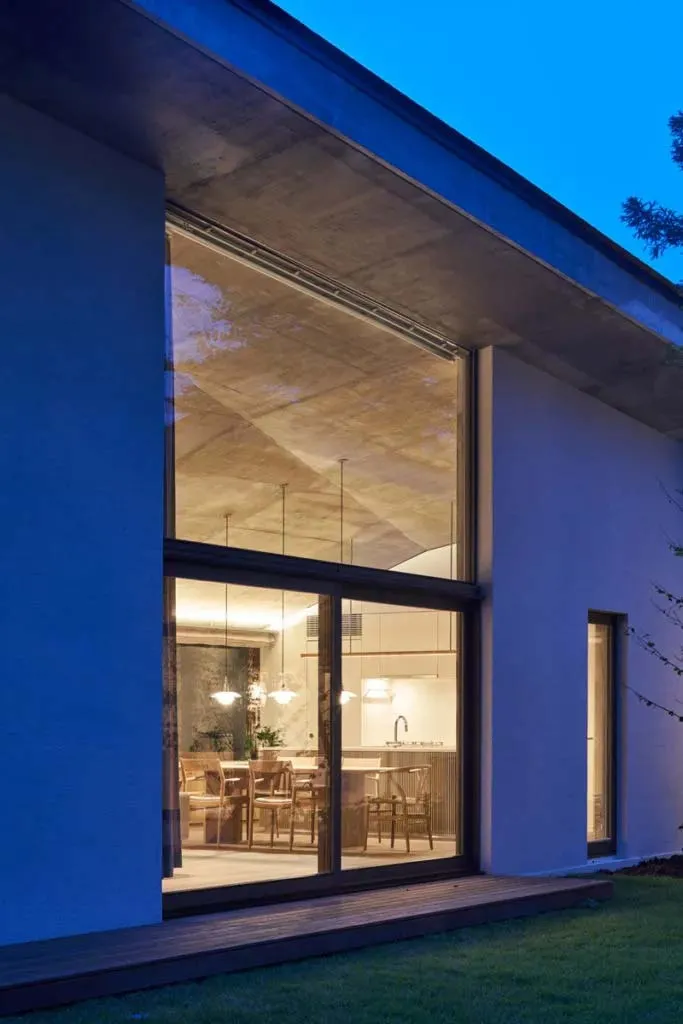 Modern minimalist kitchen interior featuring sleek concrete and glass materials.
