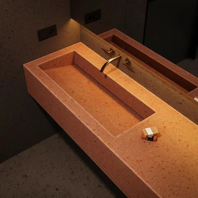 Modern bathroom with concrete sink and brass faucet.