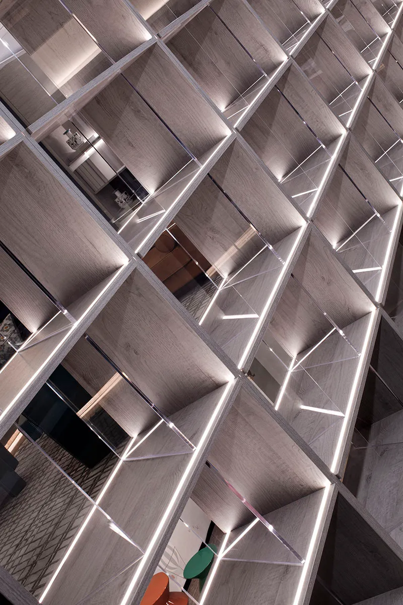 A contemporary bookshelf with wooden shelves and LED lighting.