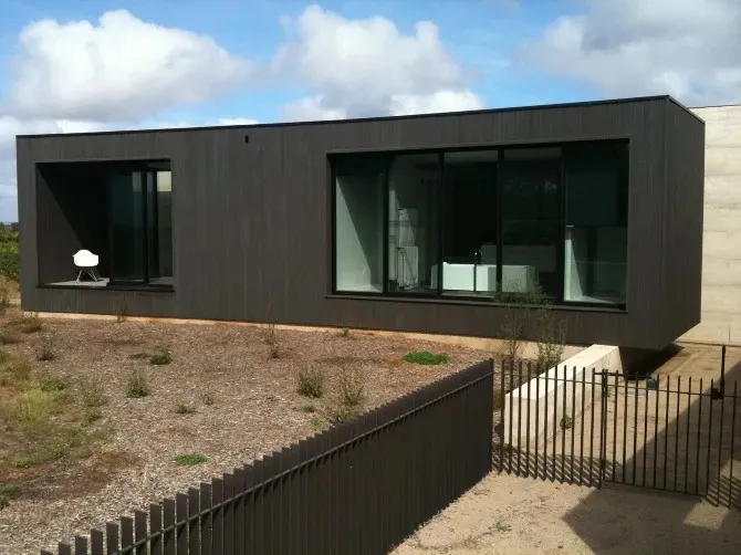 A modern black facade with a metal exterior and large windows.