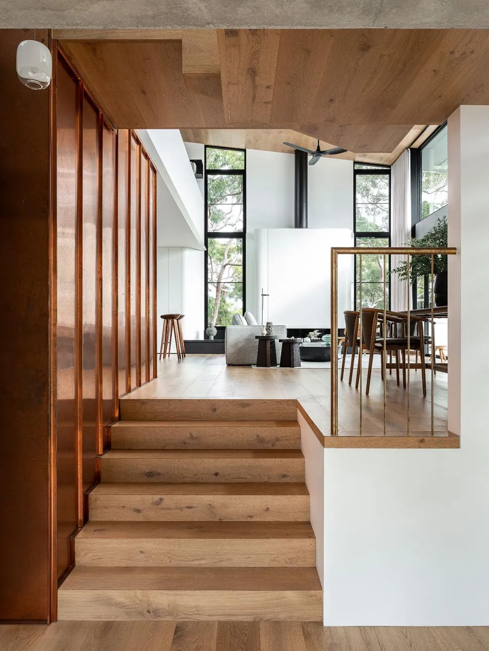 Modern living room featuring wooden flooring and large windows.