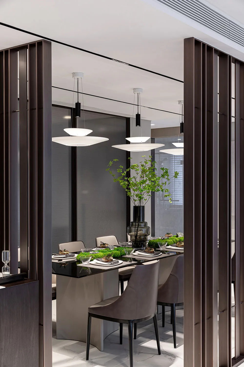 Modern dining room interior with sleek, minimalist design featuring metal and glass furniture.